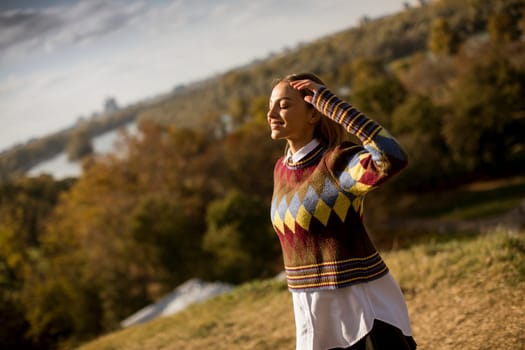 Pretty young woman walking in the autumn park on a sunny day