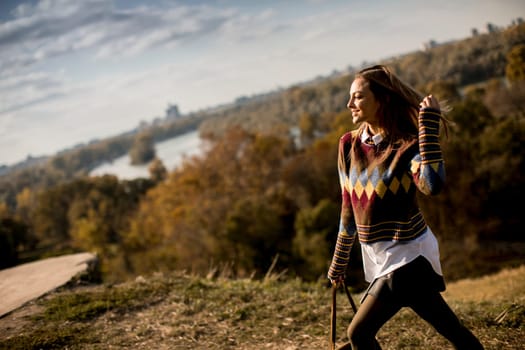 Pretty young woman walking outside at sunny autumn day
