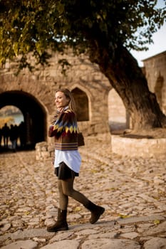 Pretty young woman walking in the autumn park on a sunny day