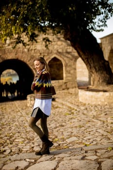 Pretty young woman walking in the autumn park on a sunny day
