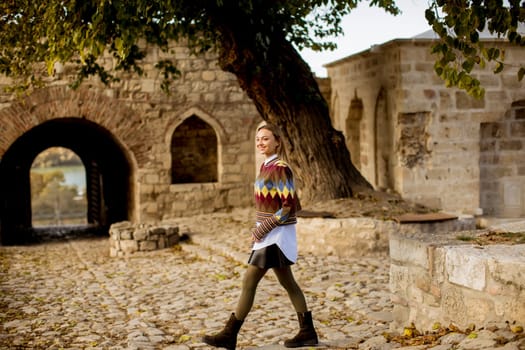 Pretty young woman walking in the autumn park on a sunny day