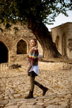 Pretty young woman walking in the autumn park on a sunny day