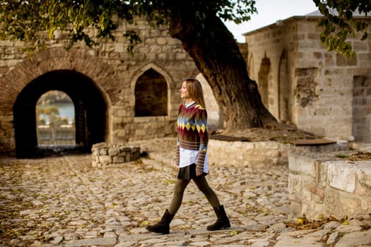 Pretty young woman walking in the autumn park on a sunny day