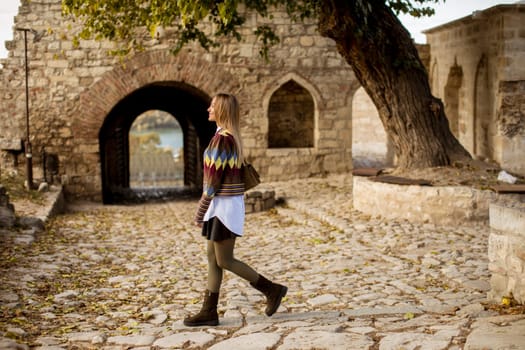 Pretty young woman walking in the autumn park on a sunny day