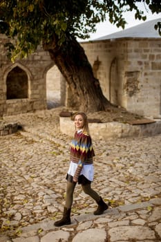 Pretty young woman walking in the autumn park on a sunny day