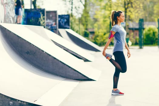 Pretty young woman having exercise outdoors
