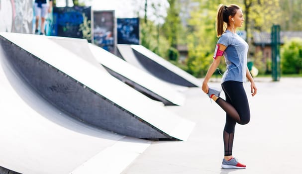 Pretty young woman stretching in the park