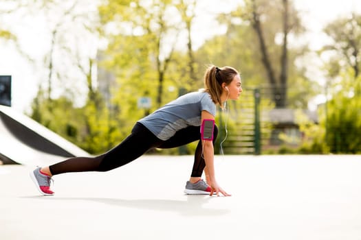 Pretty young woman having exercise in the park on a sunny day