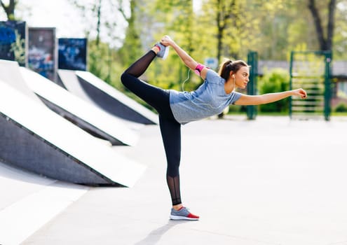 Pretty young woman stretching in the park