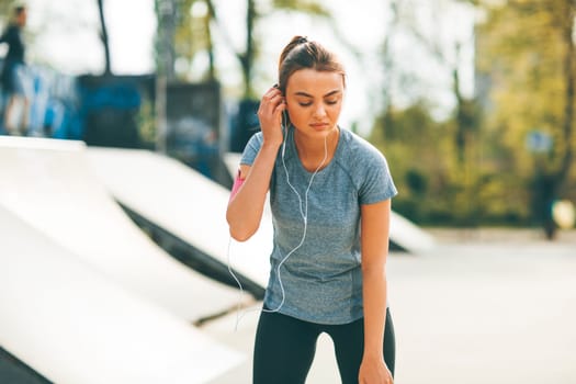 Pretty young woman having exercise in the park on a sunny day