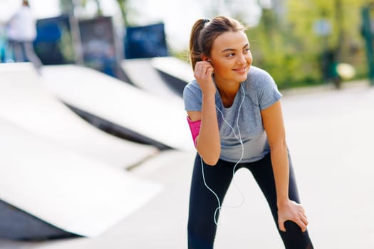 Pretty young woman having exercise in the park on a sunny day