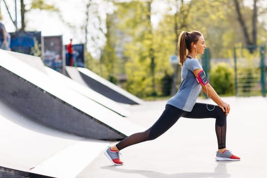 Pretty young woman stretching in the park