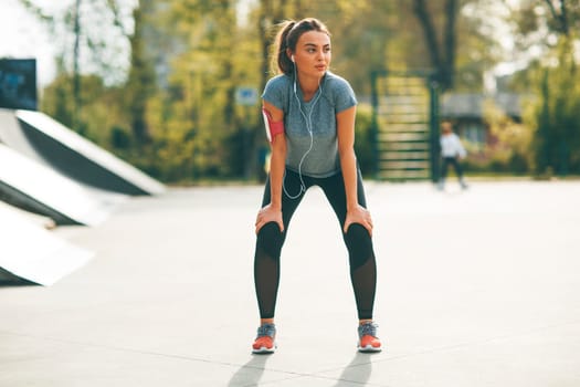 Pretty young woman having exercise in the park on a sunny day