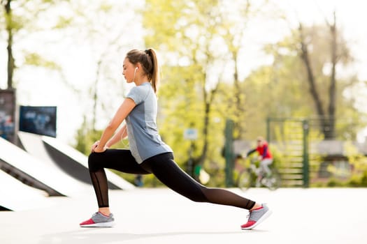 Pretty young woman having exercise in the park on a sunny day