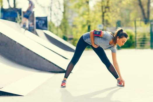 Pretty young woman stretching in the park