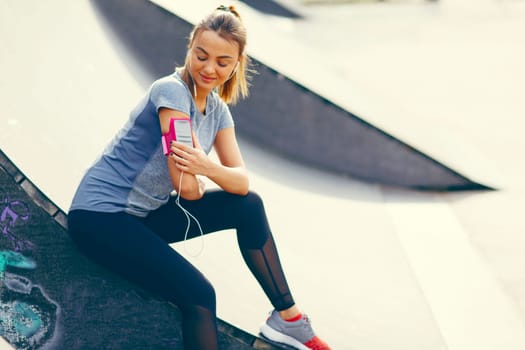 Pretty young woman relaxing during exercise in the park on a sunny day