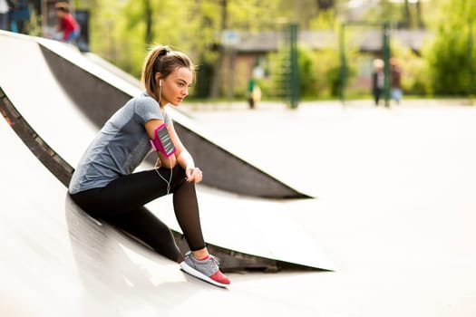 Pretty young woman having exercise outdoors