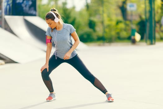 Pretty young woman having exercise outdoors
