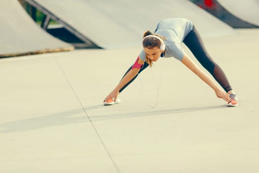 Pretty young woman having exercise outdoors