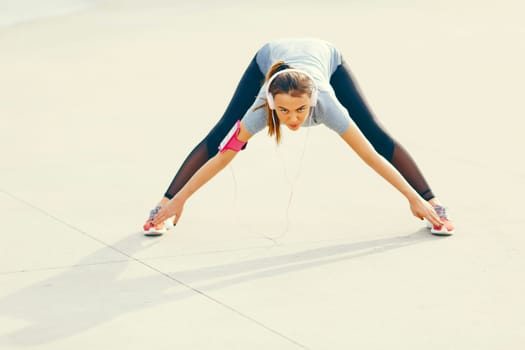 Pretty young woman having exercise outdoors