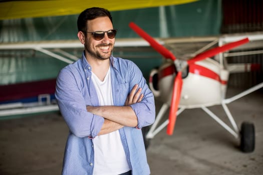 Handsome young man in the airplane hangar