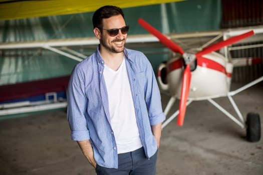 Handsome young man in the airplane hangar