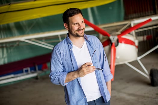 Handsome young man in the airplane hangar