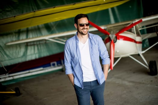 Handsome young man in the airplane hangar
