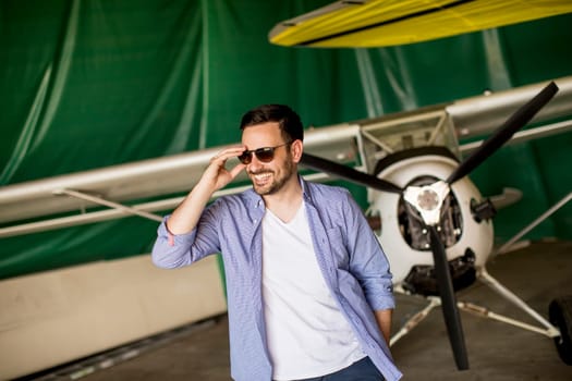 Handsome young man in the airplane hangar