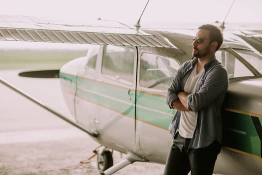 Handsome young pilot checking ultralight airplane before flight