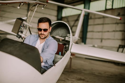 Handsome young pilot checking ultralight airplane before flight