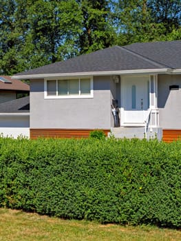 Corner and entrnace door of detached residential house on bright summer day.