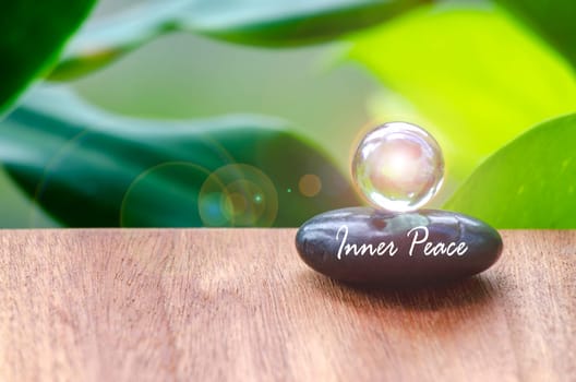 Inner peace text on zen stone with bright shining glass marble. Inner strength concept.