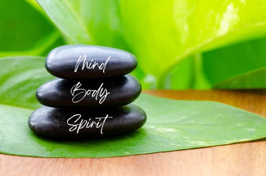 Mind Body and Spirit ext on black zen stones. Inner peace and zen concept.