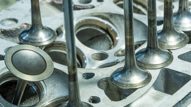 Car engine valves close up.Part of car's motor.Machinery detail of modern gasoline engine repair of cylinder head.Installing the valve of an overhauled engine.Mechanism automobile.Workshop motor car