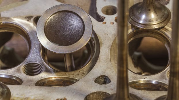 Car engine valves close up.Part of car's motor.Machinery detail of modern gasoline engine repair of cylinder head.Installing the valve of an overhauled engine.Mechanism automobile.Workshop motor car