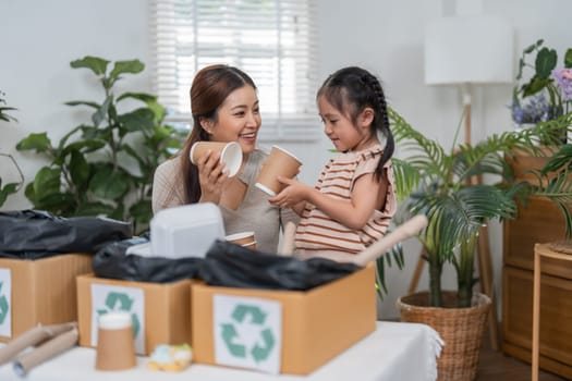 In an inviting atmosphere, a mother and daughter enjoy their time sorting paper cups and discussing the benefits of recycling, promoting a sustainable lifestyle.