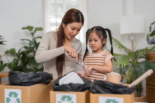 A mother demonstrates to her daughter how to effectively recycle materials in their living room, creating a space for learning about environmental responsibility and fostering a love for nature.