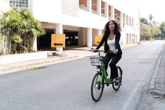 A woman happily rides her green bicycle down a city street, capturing the joy of sustainable transportation and the essence of freedom.