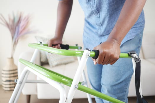 Individual demonstrates mobility aid usage while dressed casually at home.