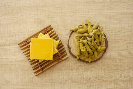 Yellow turmeric and soap on table