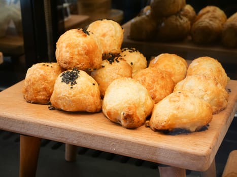A variety of golden pastries served on a rustic wooden tray indoors.
