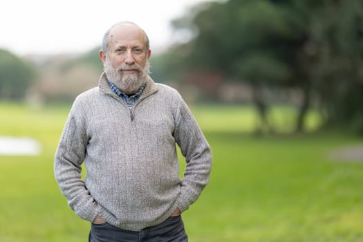 Portrait of a confident, relaxed senior man enjoying a leisurely day in the park, embodying a sense of peace and contentment