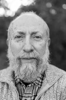 Black and white portrait of a contemplative senior man with a long white beard