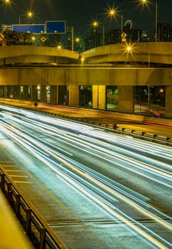 Bangkok, Thailand - Jan 10, 2025 - A nightscape view with bright glowing light trails effect of many cars headlights and rear lights on urban expressway of Bangkok. Long exposure for Light curve lines, use it as wallpaper, Poster and Copy space, Selective focus.