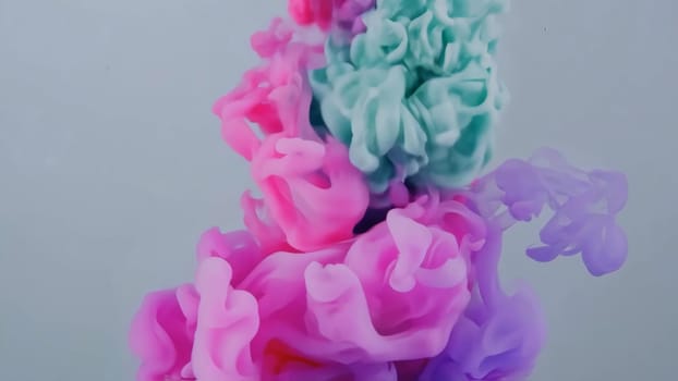 Vibrant hues of pink and teal flow together as ink and liquid paint swirl and mix. This abstract backdrop showcases the beauty of color in fluid motion, creating a stunning visual experience.