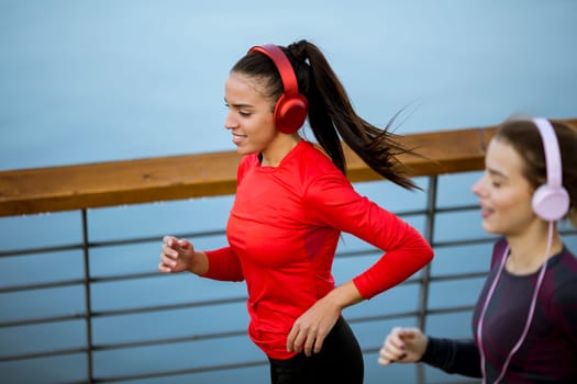 Scenery of two female joggers pursuing their activity in urban outdoors