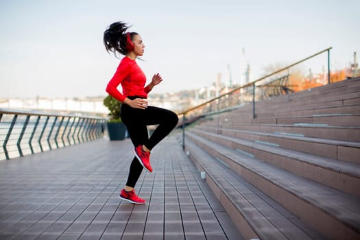 Fitness woman jumping outdoor in urban enviroment