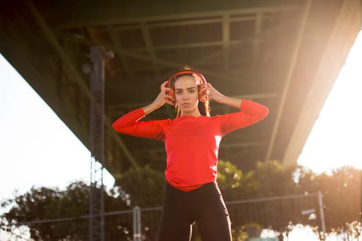 Attractive young female runner taking break after jogging outdoors