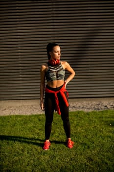 Pretty young woman takes a break after running in the urban area